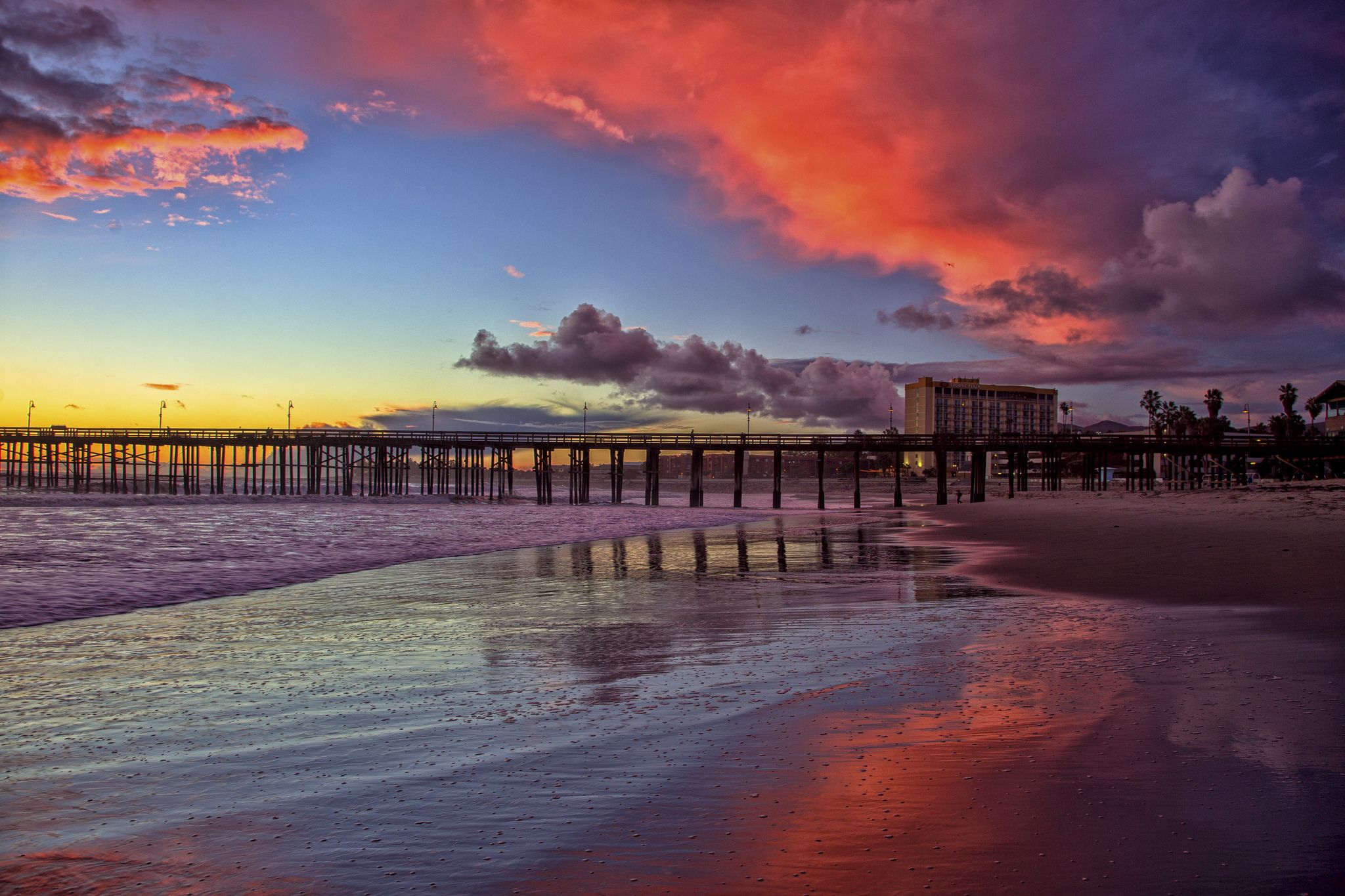 The setting sun behind the Ventura Pier creates beautiful colors in the clouds and reflected in the wet beach sand. We live in a beautiful area.